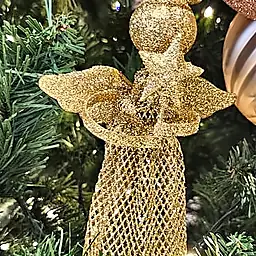 Anjo dourado entre bolas rosé na árvore